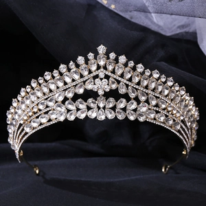 Gros plan sur la couronne de mariée dorée avec des strass étincelants sur velours noir