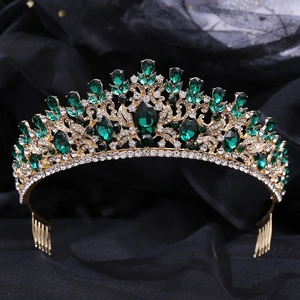 Macro detail of Baroque bridal tiara with emerald crystals and gold leaf base texture