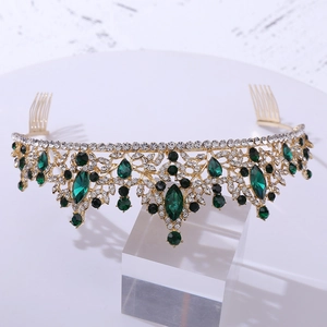 Detailed view of bridal crown with emerald green gems and rhinestones on gold alloy base