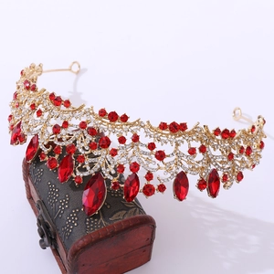 Macro shot of rose gold luxury crown with red crystals on a vintage wooden box