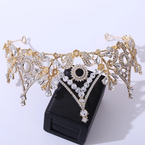 Luxurious Baroque bridal crown with gold plating and crystals on a black display stand