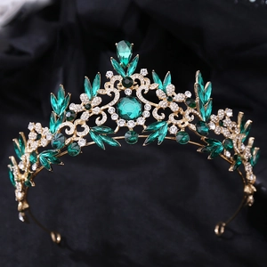 Vue détaillée de la couronne baroque de luxe avec cristaux verts et strass sur base dorée