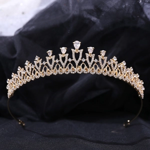Close-up of golden bridal crown with intricate heart shaped metalwork and clear zircons