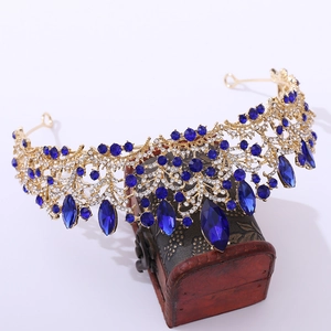 Detailed shot of rose gold bridal crown with blue crystals on a vintage wooden box