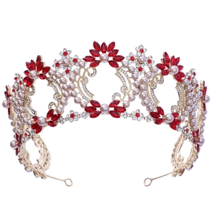 Macro detail of luxury Baroque bridal crown with red crystals and pearls in gold openwork