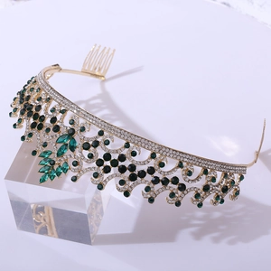 Detailed side view of baroque gold crown with emerald green stones and built-in hair combs