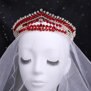 Gros plan du diadème de mariée avec cristaux rouges en goutte et strass brillants sur métal doré