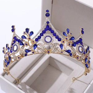 Detailed close-up of golden baroque bridal crown with blue crystals and floral metalwork