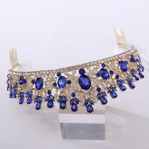 Macro detail of golden bridal tiara featuring deep blue crystals and intricate rhinestones