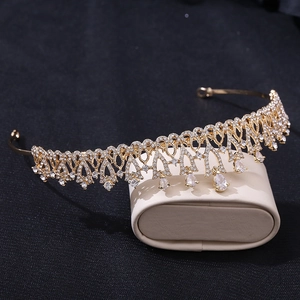 Close-up of golden bridal crown featuring intricate filigree and pear-cut crystal drops