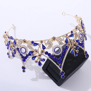 Detail of luxury baroque crown with blue crystals and floral diamond inlay on golden frame