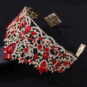 Detail of golden Baroque crown with red rhinestones and crystal flower vine patterns