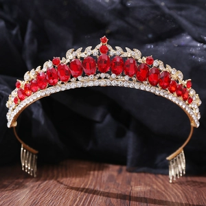 Détail d'un diadème de mariée de luxe avec cristaux rouges et strass sur base dorée