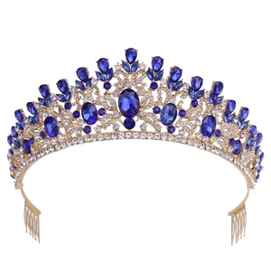 Close-up of golden crown hair comb with deep blue crystals and white rhinestones