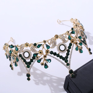 Macro detail of luxury baroque bridal crown with emerald green crystals and gold metal vine