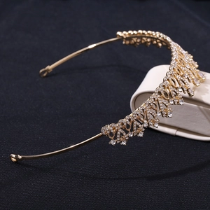 Macro side view of a bridal gold crown with shimmering zircon flowers and teardrop crystals