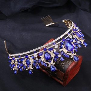 Détail d'un diadème baroque doré avec cristaux bleus et strass sur une boîte en bois