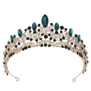 Detailed close-up of rose gold bridal crown with deep green crystals and white rhinestones