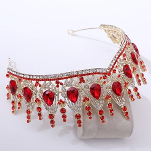 Dettaglio della corona barocca dorata con cristalli rosso rubino ed eleganti nappe