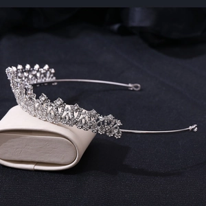 Close-up of silver bridal tiara with floral heart patterns and sparkling rhinestones