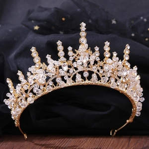 Macro detail of gold bridal crown with faceted crystals and pearls on star tulle