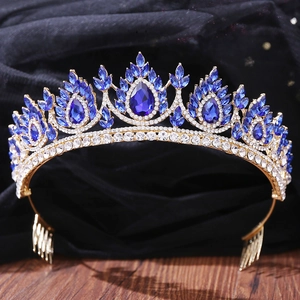 Detailed close-up of Baroque gold crown with blue teardrop crystals and white rhinestones