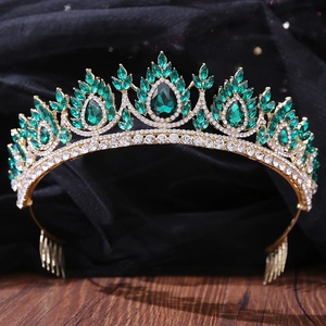 Detailed view of emerald green crystal bridal tiara with gold hair comb and rhinestones