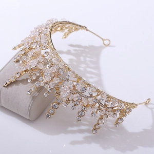 Detail of golden bridal crown with hand-strung crystals and rhinestones on a display stand