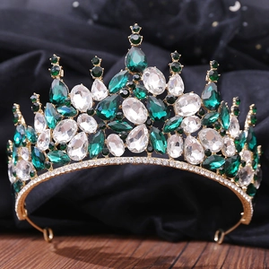 Gros plan d'une couronne de mariée avec cristaux émeraude et diamants sur bois