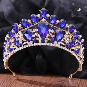Close-up of golden bridal crown with deep blue teardrop gems and sparkling rhinestones