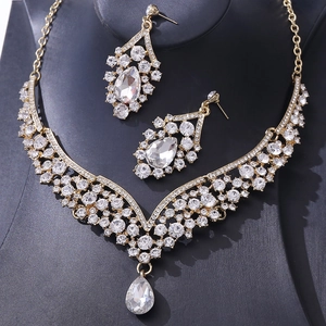 Macro shot of gold jewelry set with teardrop crystals and sparkling rhinestones