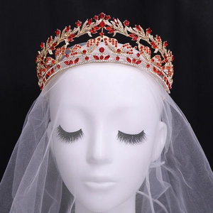 Dettaglio ravvicinato di una corona da sposa vintage con strass rossi a forma di farfalla