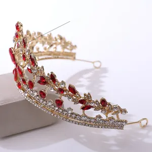 Close-up of luxury bridal crown featuring red pear-cut rhinestones and gold metal