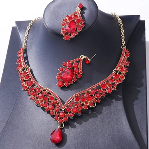 Detailed macro view of the gold-tone bridal jewelry set with red teardrop crystal accents