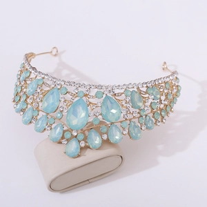 Detailed macro view of gold tiara with light blue teardrop crystal and rhinestones
