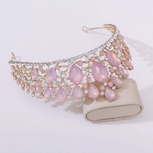 Close-up of luxury gold bridal crown with pink pear-cut crystals and sparkling rhinestones