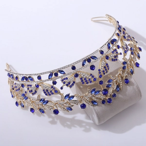 Dettaglio ravvicinato della corona vintage dorata con strass blu e motivi a farfalla