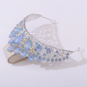 Close-up of a silver bridal crown featuring blue teardrop rhinestones and clear crystals