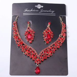 Detail of bridal jewelry set with red crystal teardrop pendants and golden alloy finish