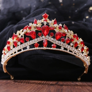 Macro view of luxurious gold metal crown with red pear-shaped rhinestones and white crystals