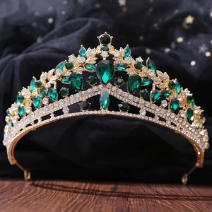 Macro detail of emerald waterdrop gems and rhinestones on a gold bridal tiara