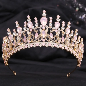 Gros plan d'une couronne dorée avec cristaux roses en forme de poire et strass
