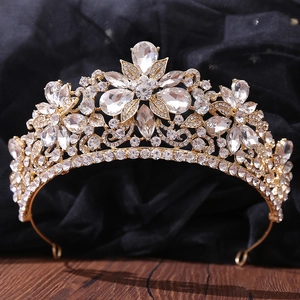 Dettaglio della corona da sposa dorata con motivi a foglia e dettagli in cristallo lucido