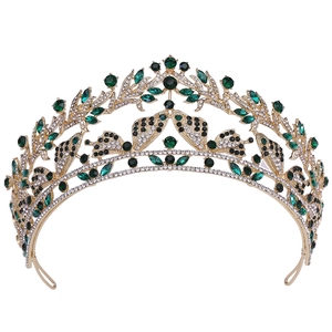 Dettaglio macro della corona da sposa dorata con gemme verdi e motivi a farfalla in cristallo