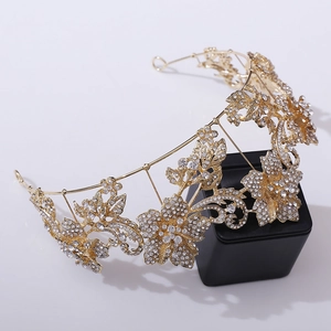 Close-up of golden floral bridal tiara with white rhinestones and leaf details
