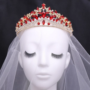 Luxurious gold wedding crown with red crystals and teardrop gems on bridal veil
