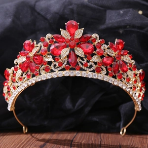 Elegante corona da sposa con strass rossi e motivi a foglia d'oro su sfondo in legno scuro