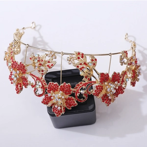 Close-up of golden bridal tiara featuring red crystals and iridescent floral stones