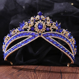 Close-up of luxury bridal tiara with deep blue gemstones and pavé crystals on gold base
