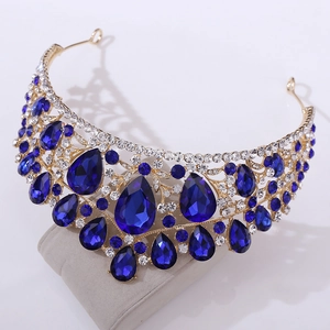 Macro detail of luxury bridal crown with deep blue pear-shaped crystals and gold alloy base